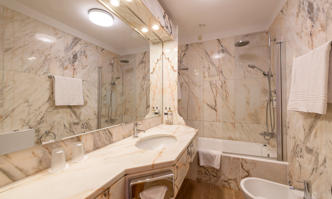 The Superior Room of The Pousada Viana do Castelo has a bathtub with a shower and a counter with a marble sink